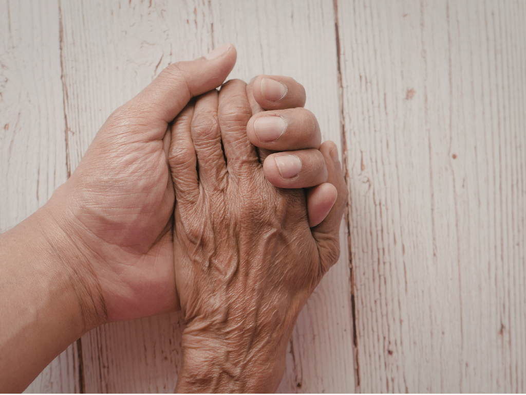 Mano entrelazada de abuelito con cuidador